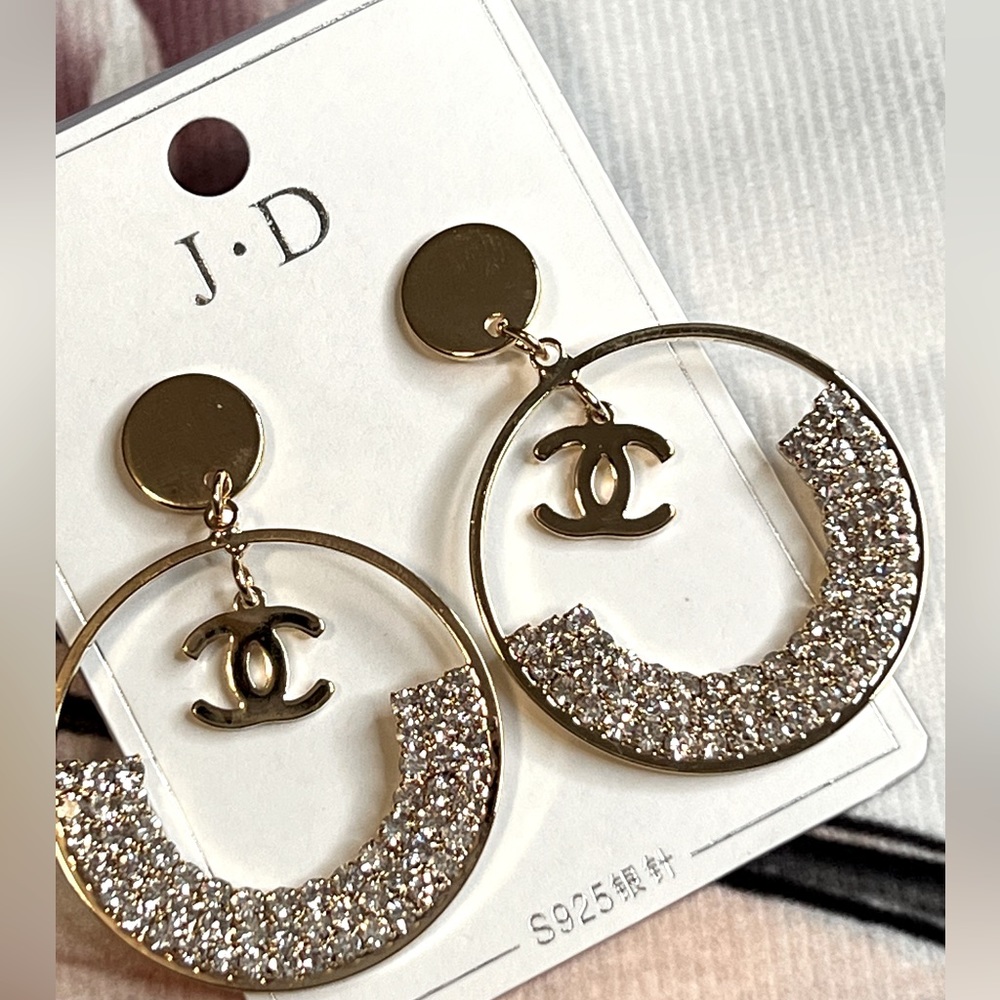 Fashion dangling earring with initials “C”.